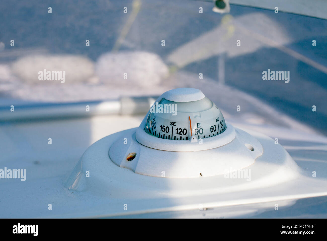 Close-up shot della bussola bianco su bianco con una barca a motore. Foto Stock