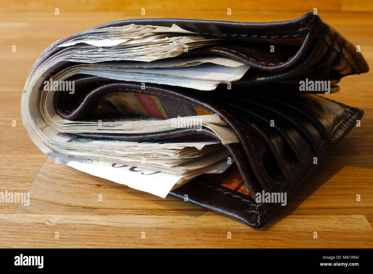 Un portafoglio pieno di contanti, rendendo difficoltosa la chiusura. Dando l'impressione di ricchezza. Foto Stock