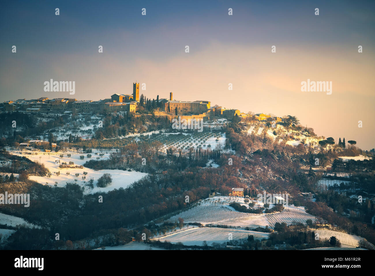 Neve in Toscana, panorama invernale al tramonto. Radicondoli village, alberi di olivo e vigneti, Siena, Italia Europa. Foto Stock