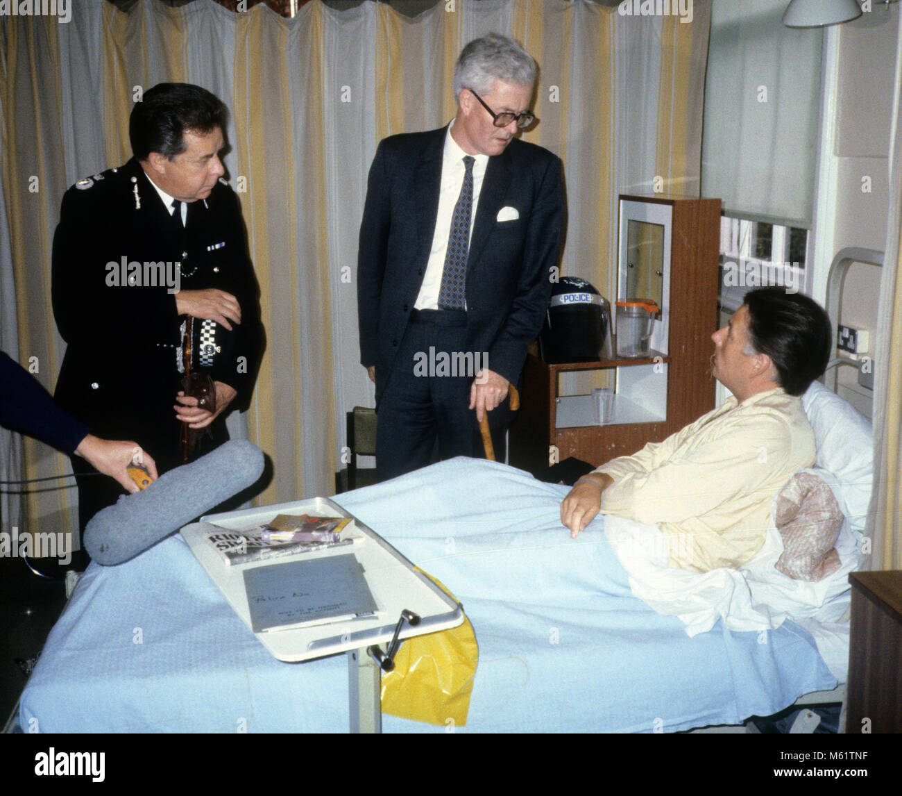 British Home Secretary Douglas Hurd feriti in visita ufficiale di polizia in ospedale dopo il Tottenham sommosse del Broadwater Fattoria nel 1985. Sulla sinistra è vice commissario della Metropolitan Peter Imbert che più tardi divenne Barone Imbert. Foto Stock