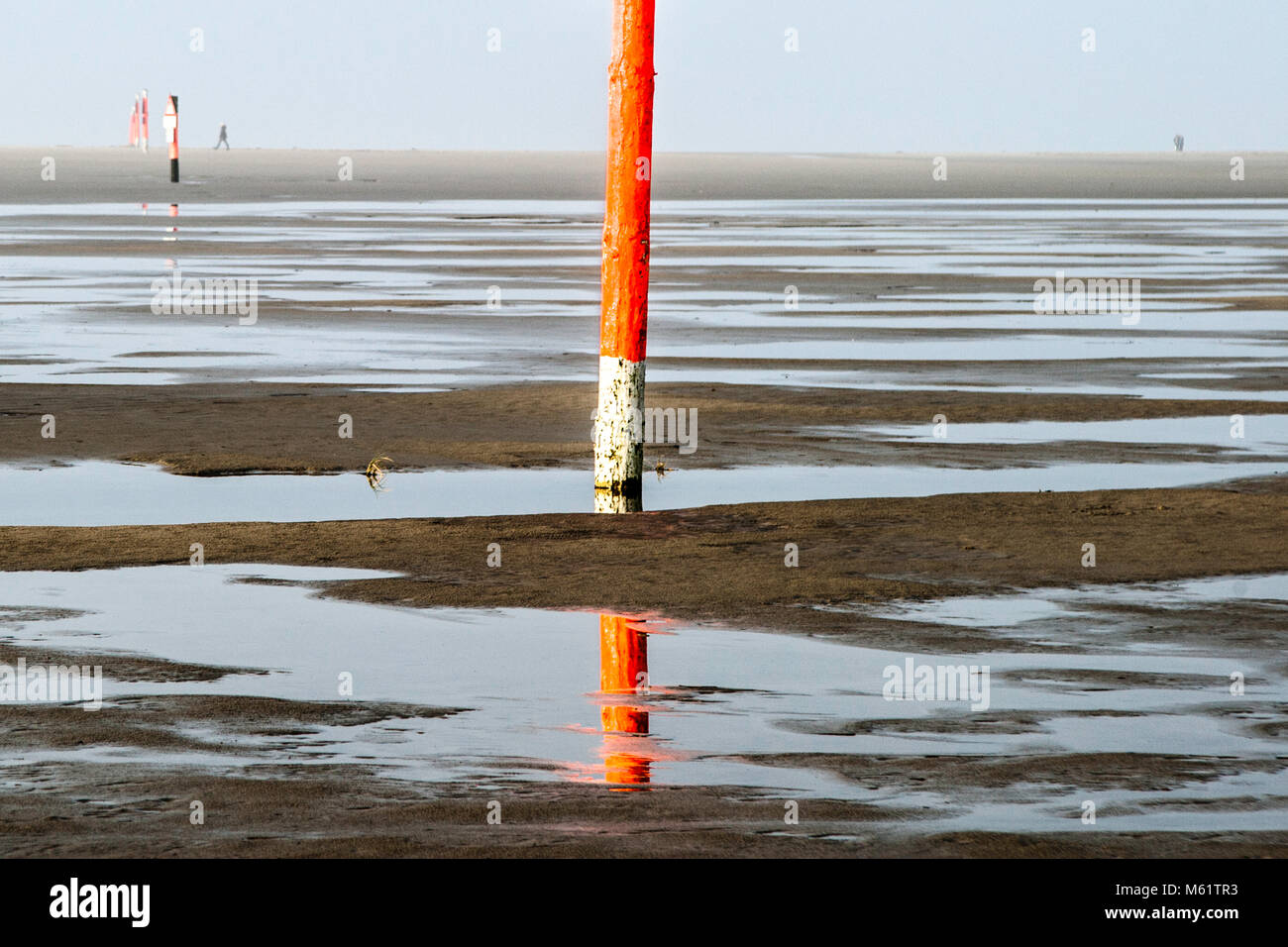 Spiaggia buggy e zona di vela presso la spiaggia di Sankt Peter-Ording, Germania. Palo arancione e il suo riflesso in una pozza, bassa marea spiaggia nella località balneare di St Peter Ording Germania Foto Stock