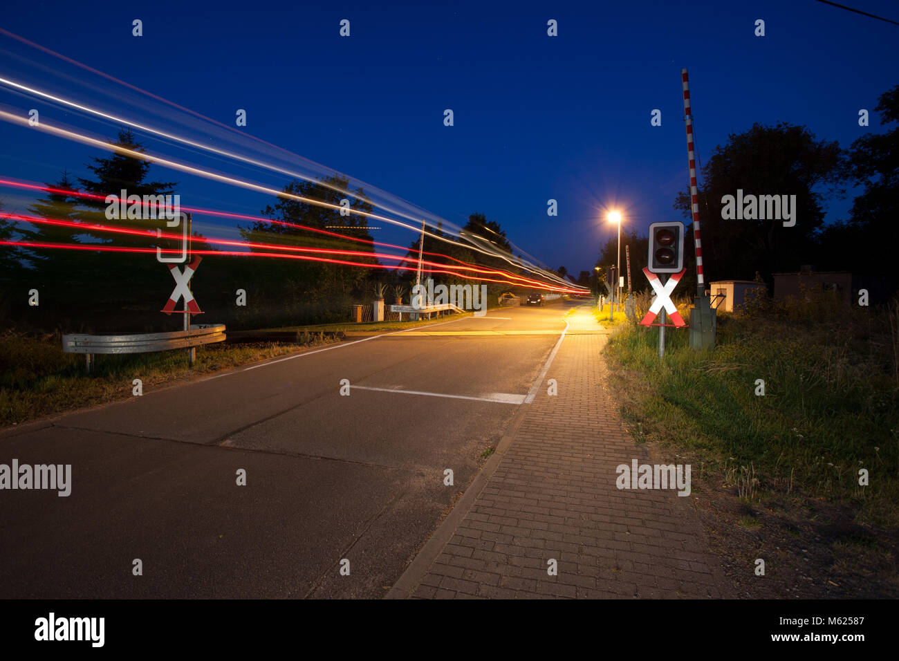 Passaggio a livello di notte, la luce la via di passaggio auto. Nel Land di Brandeburgo, in Germania, l'Europa. Foto Stock