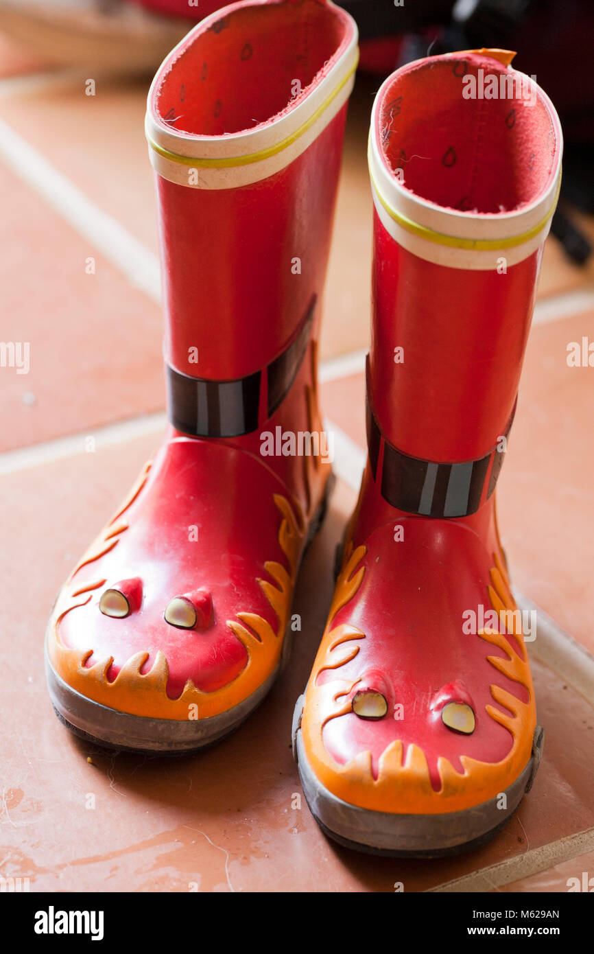 Una coppia di bambini stivali da pioggia sul pavimento - USA Foto Stock