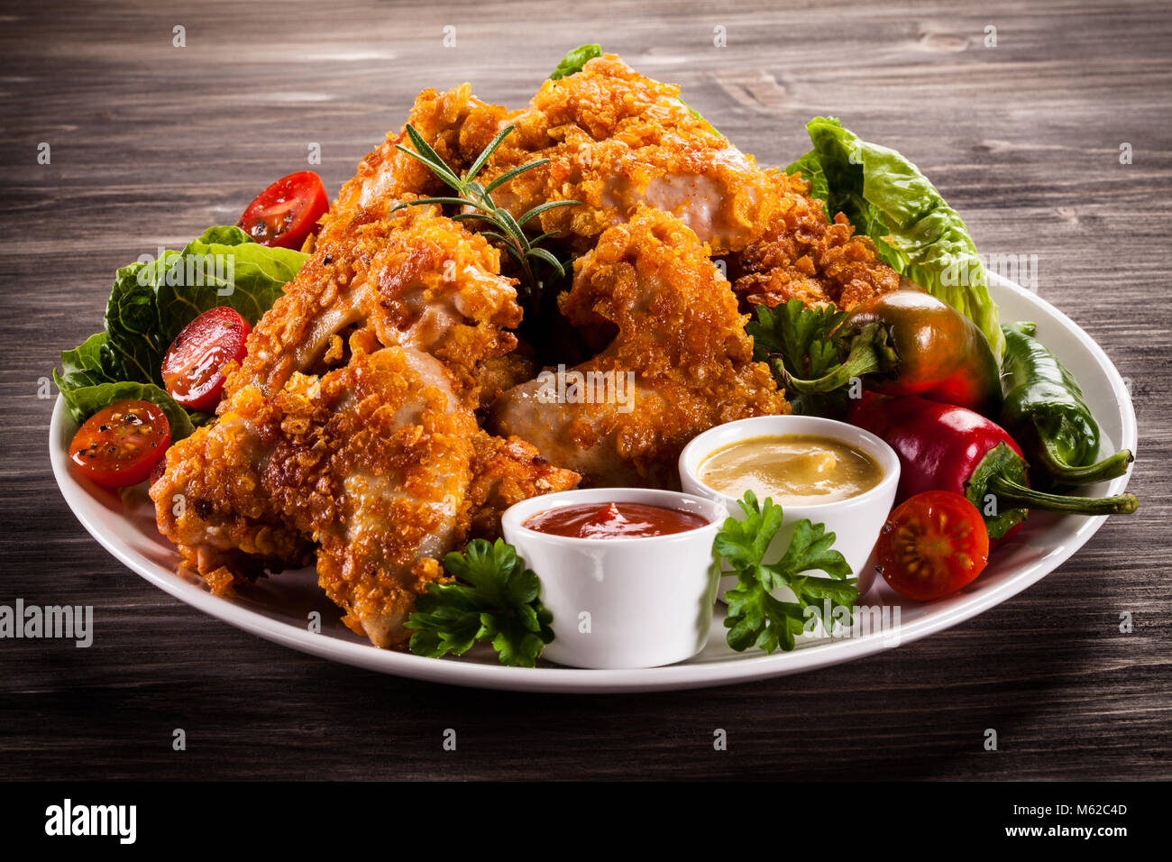 Fried Chicken Nuggets e verdure su sfondo di legno Foto Stock