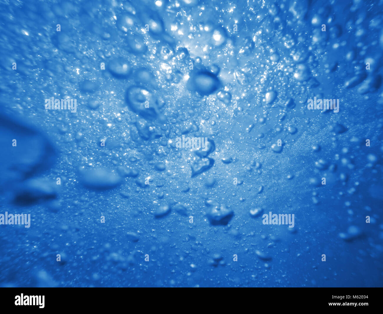 Mare sottomarino bolle e schiuma con raggi di luce solare, sfondo naturale Foto Stock