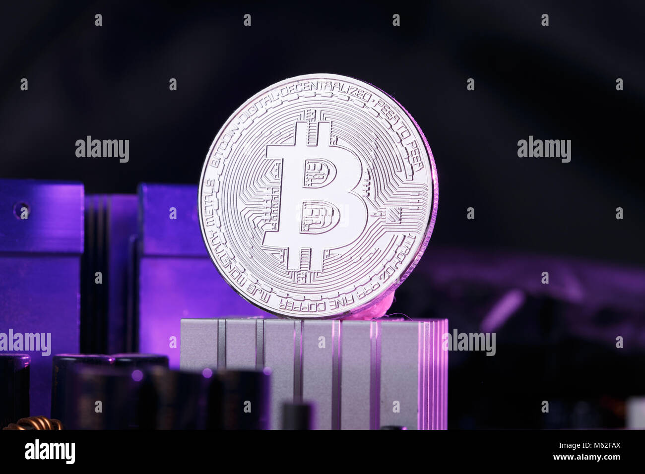 Foto di moneta virtuale, bitcoin e processore su sfondo rosa Foto Stock