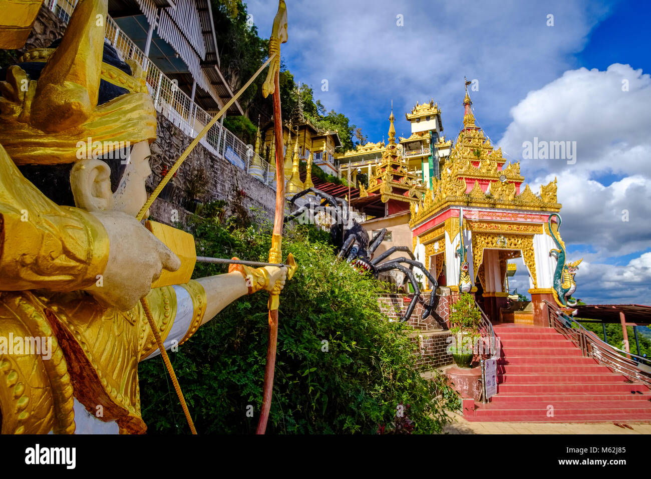 La scultura del principe Kummabhaya mirando a uccidere un grosso ragno con la sua freccia all'entrata di Pindaya Shwe Umin grotta Foto Stock
