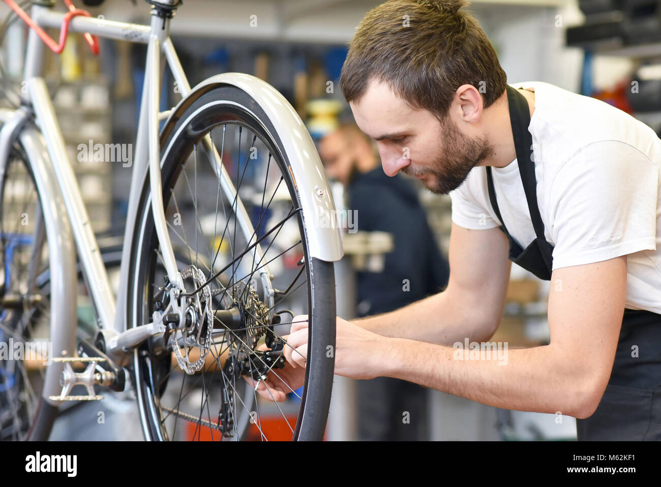 Amichevole e competente e meccanico di bicicletta in una riparazione in  officina una bici Foto stock - Alamy