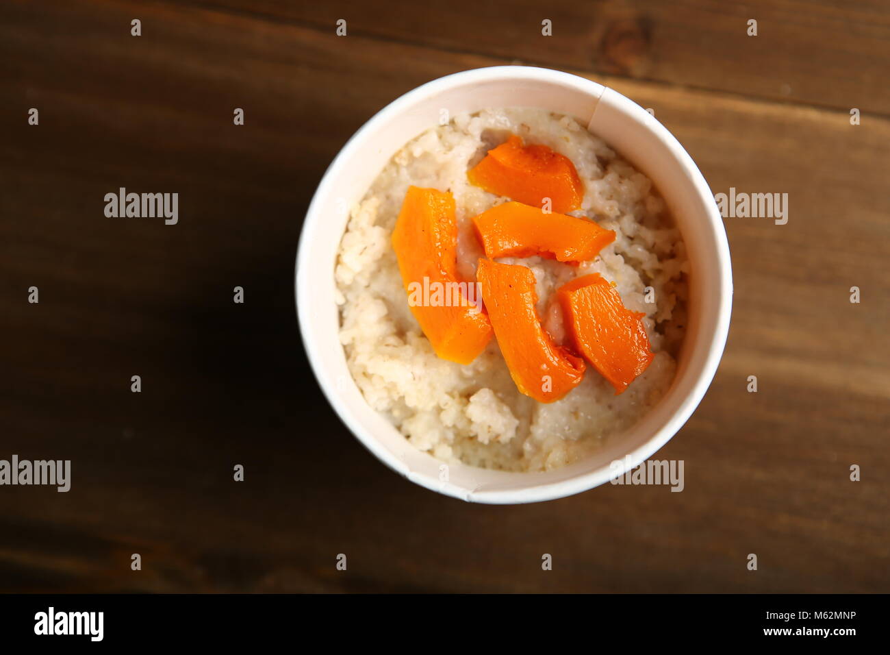 Low-calorie porridge per una dieta sana e stile di vita. La consegna a casa in un bicchiere di carta, contenitore. Confezione realizzata con materiali naturali. Orzo Foto Stock