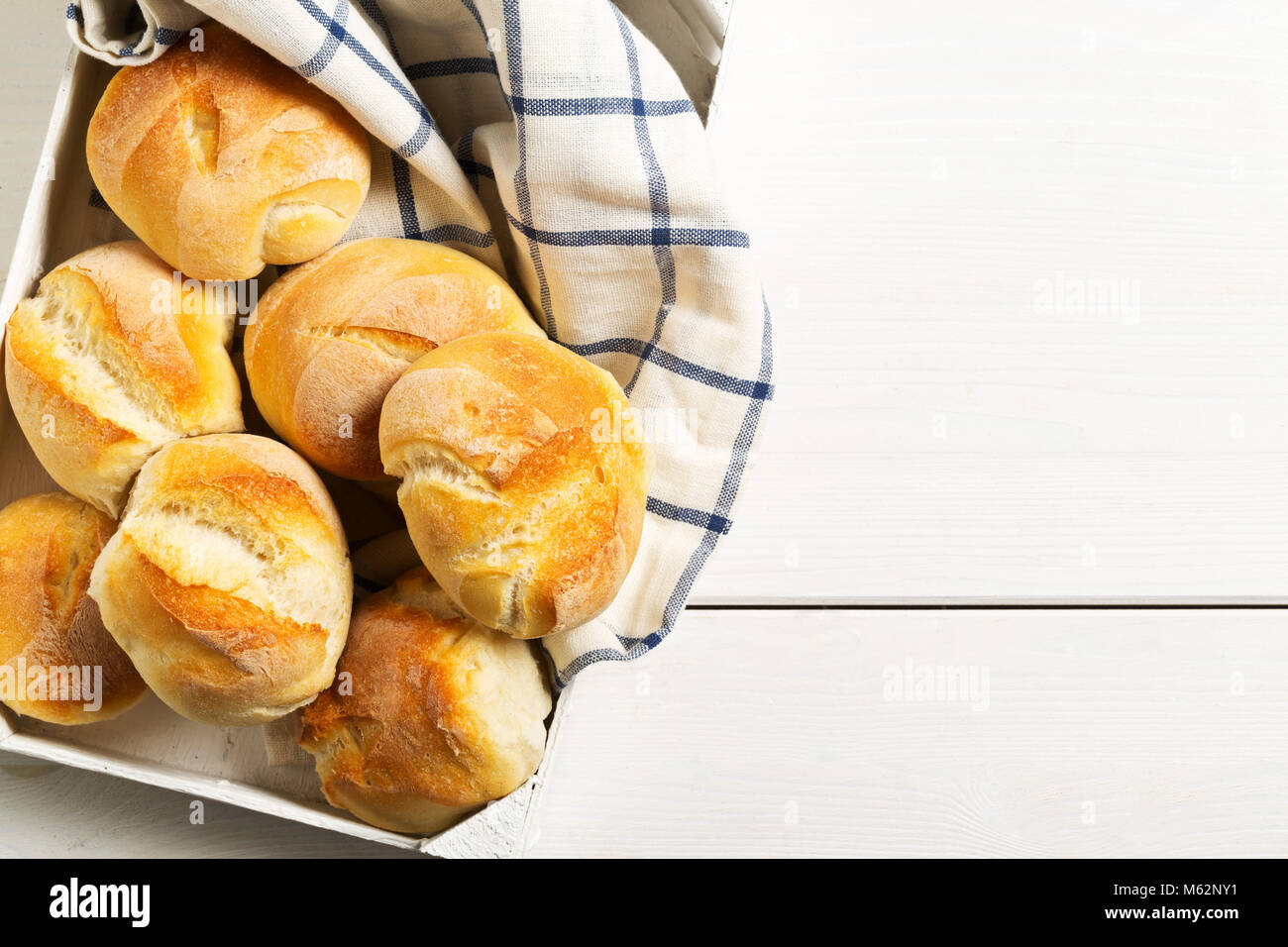 Mazzetto di interi, freschi di forno focacce di grano con spighe di grano sul vassoio su bianco tavolo in legno vista in pianta da sopra con lo spazio di copia Foto Stock