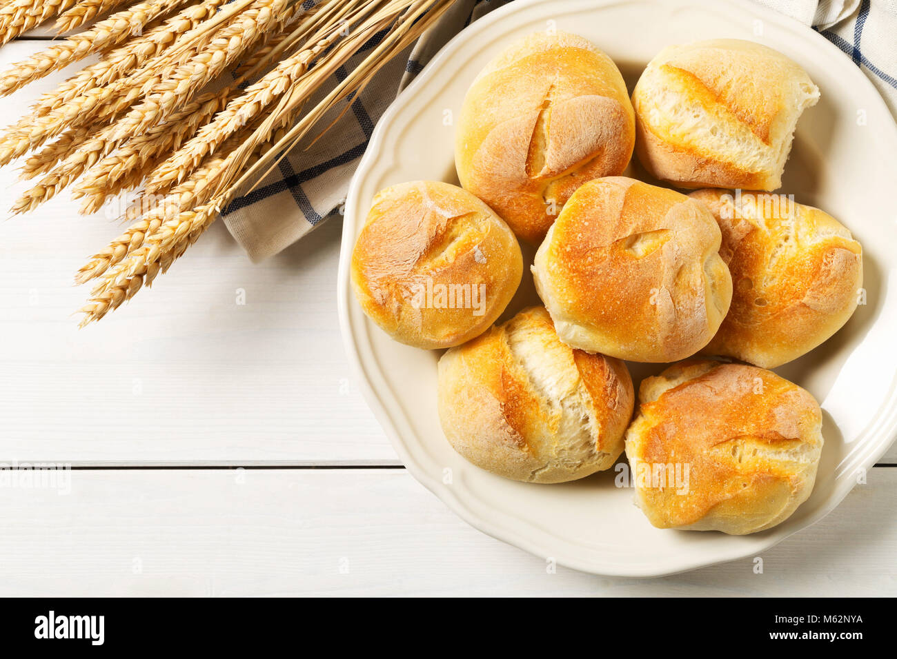 Mazzetto di interi, freschi di forno focacce di grano con spighe di grano sulla piastra su bianco tavolo in legno vista in pianta da sopra con lo spazio di copia Foto Stock Mazzetto di interi, freschi di forno focacce di grano con spighe di grano sulla piastra su bianco tavolo in legno vista in pianta da sopra con lo spazio di copia Foto Stock