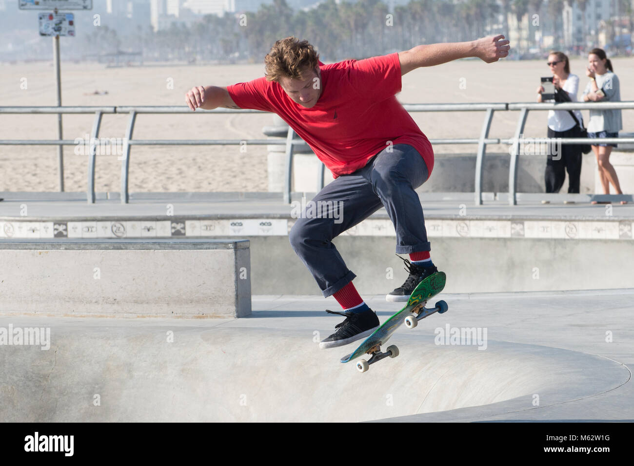 Un guidatore di skateboard di eseguire trick a Venice Beach Skatepark, Santa Monica, California, Foto Stock