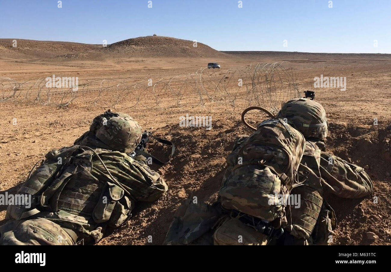 Soldati dal Bravo società "Bushmasters", 1° Battaglione, 184Reggimento di Fanteria, California Army National Guard, individuare il coperchio e tornare il fuoco dopo la ricezione di simulazione di piccole armi da fuoco durante un esercizio di formazione nei pressi di Amman in Giordania il 2 febbraio 2018. Il corso basato su scenari ammessi Bushmaster leadership per valutare le loro capacità dell'azienda per impostare un blocco stradale, creare una voce del punto di controllo, e negare il nemico di accedere alle principali del terreno. (U.S. Esercito Foto Stock