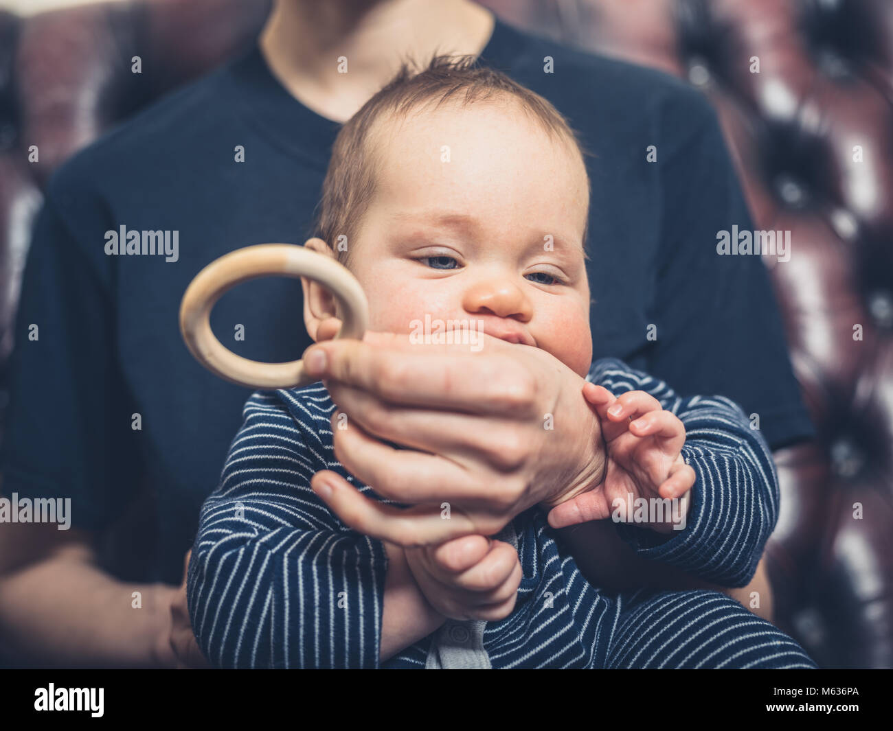 Una madre sta offrendo il suo bambino un anello di dentizione a rosicchiare Foto Stock