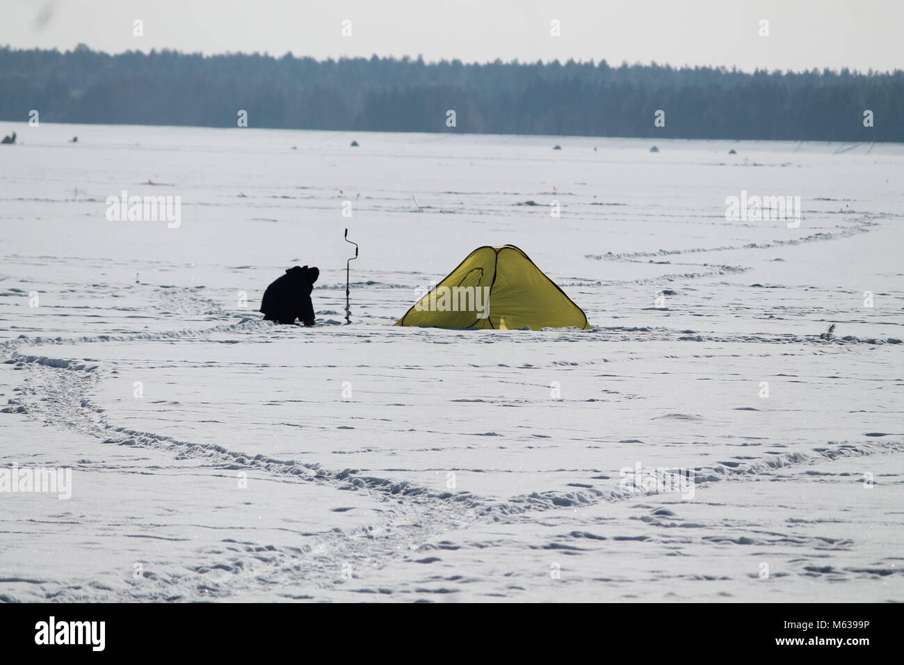 Gli uomini di pesce il campeggio sul mare ghiacciato in inverno freddo giorno di sole terra dessert Foto Stock