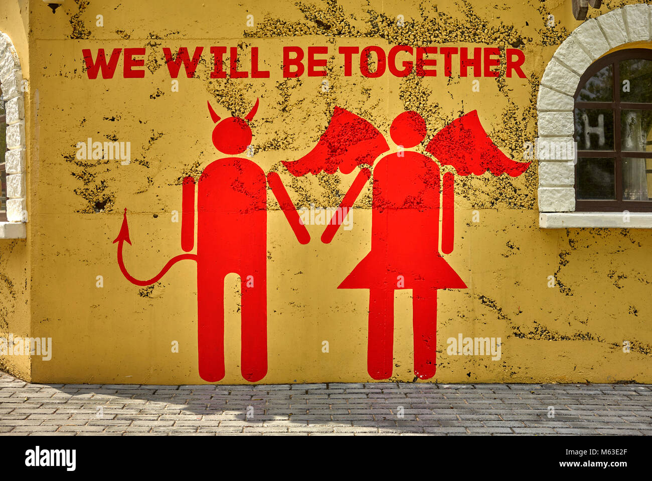 Wall Art e graffiti di un inusuale accoppiamento di un diavolo e Angelo Foto Stock