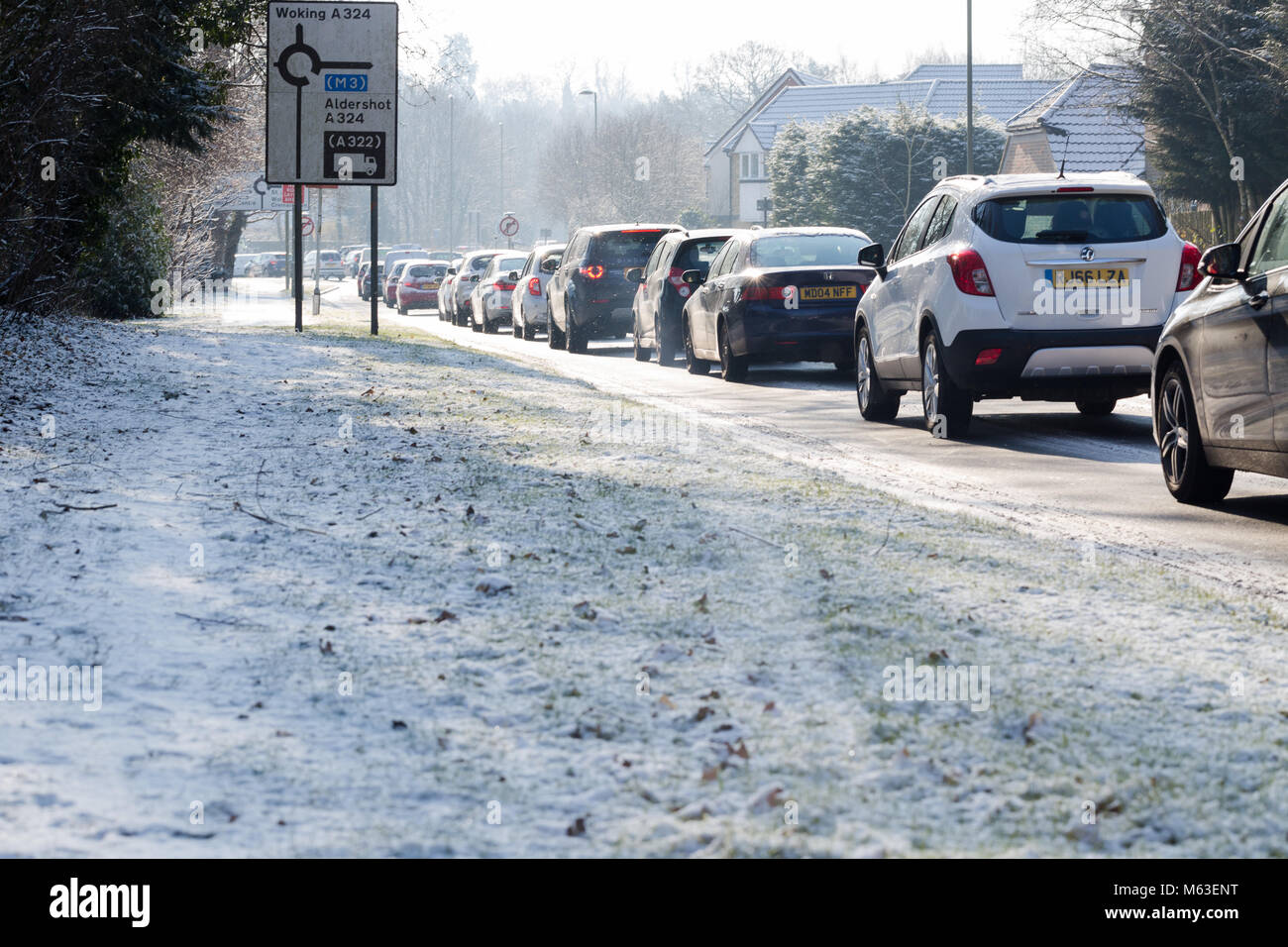 Goldsworth Park, Woking, Surrey, Regno Unito. 28 feb 2018. Meteo REGNO UNITO: lentamente guidato vetture su strada sdrucciolevole nelle ore mattutine di Woking, Surrey facendo lunghe congestione. Credito: Tom Krok/Alamy Live News Foto Stock