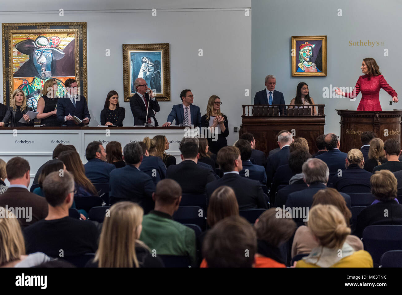 Londra, Regno Unito. 28 Feb, 2018. Banditore Helena Newman (raffigurato in abito rosso) prende l'impressionista e moderna sera vendita da Sotheby's New Bond Street, Londra. Credito: Guy Bell/Alamy Live News Foto Stock