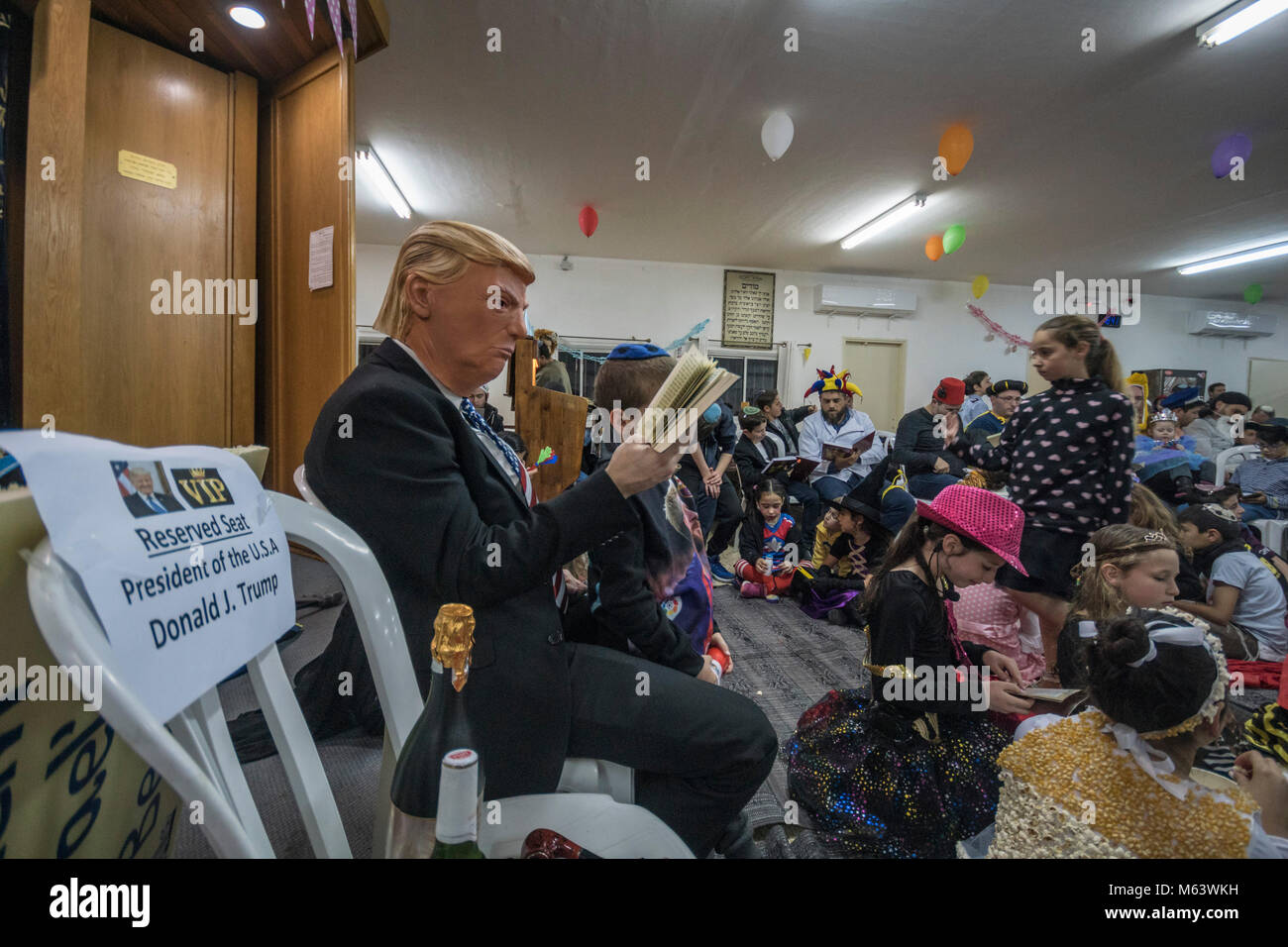 Elkana, Israele. 28 Feb, 2018. Purim holiday celebrazioni, Elkana, Israele. Febbraio 28th, 2018.. Un uomo con una maschera di briscola e altri personaggi in costume celebrare la festa ebraica di Purim. In questa vacanza ebrei traditionaly vestito in costumi, leggere la chiocciola di Esther, una storia su un anti-ebraica complotto fallito nell antica Persia e fare un racket ogni volta che il nome di Haman, l'antagonista principale, è menzionato. Credito: Yagil Henkin/Alamy Live News Foto Stock