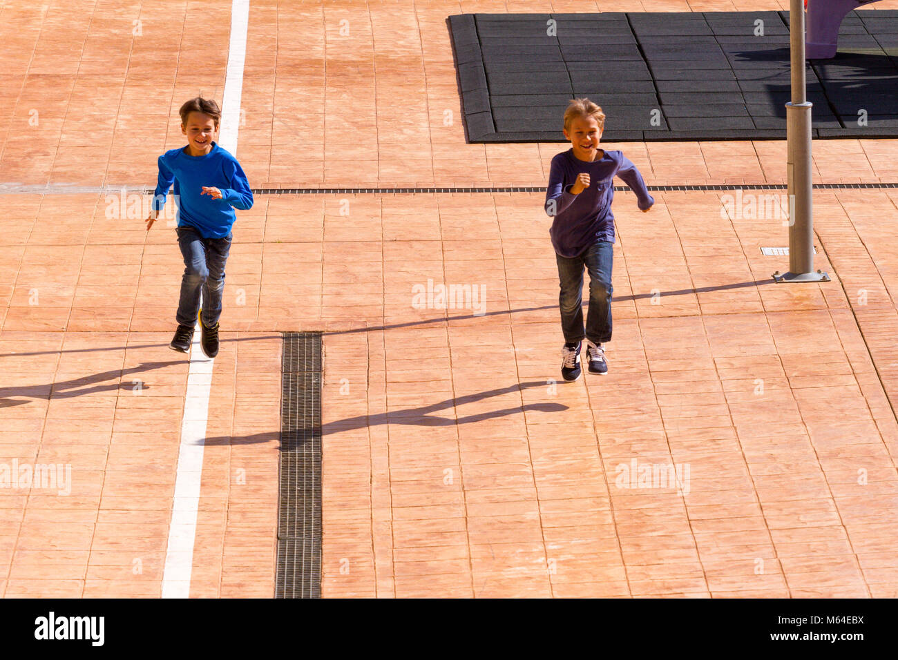 Kids jumping, corsa all'aperto al giorno di sole Foto Stock