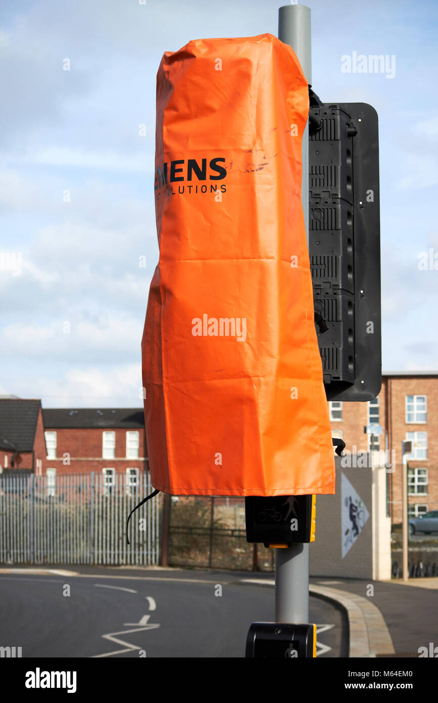 Orange copertura impermeabile sopra appena installato ancora essere commissionato il traffico di attraversamento pedonale luci da Siemens nel Regno Unito Foto Stock