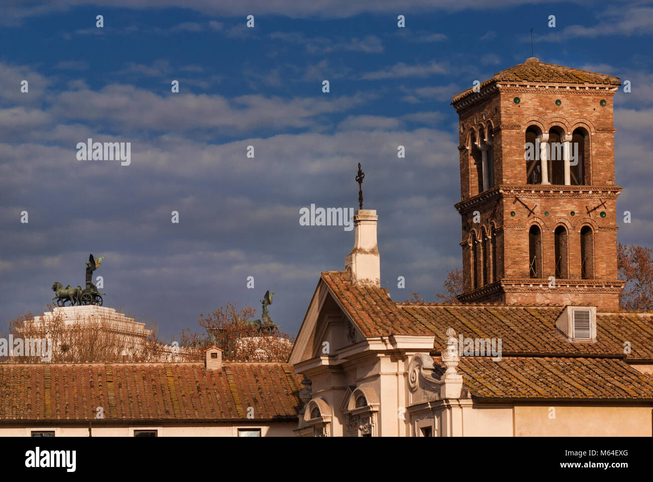 Vista invernale di San Bartolomeo all Isola il campanile medievale con il Vittoriano Moument in background con le nuvole, nel centro storico di Roma Foto Stock
