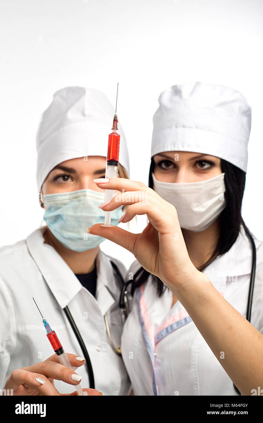 Due medici di sesso femminile preparare una iniezione o il prelievo di campioni di sangue per il paziente di analisi Foto Stock