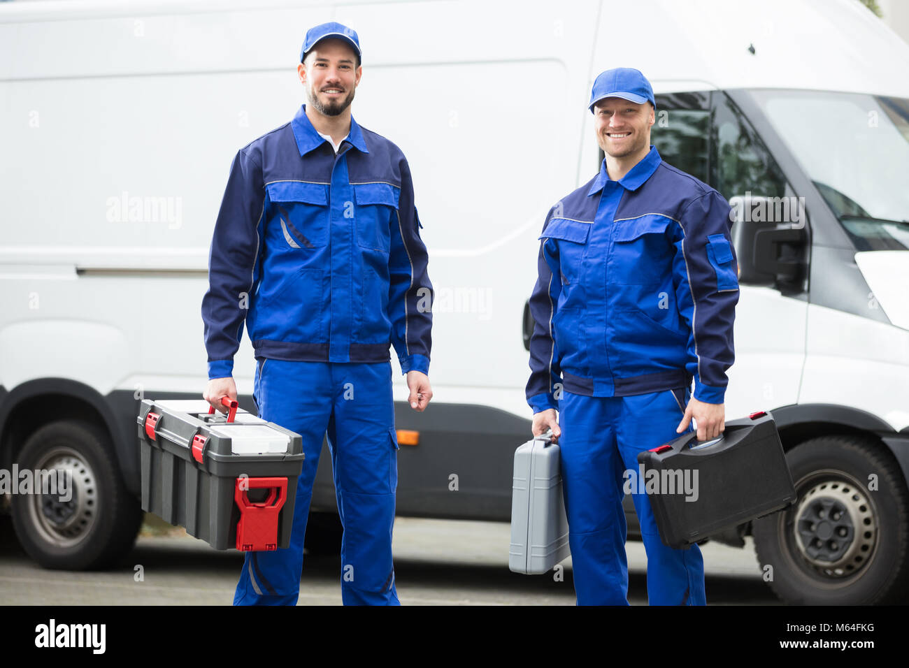 Ritratto di un felice giovane lavoratore di sesso maschile Azienda Toolbox Foto Stock