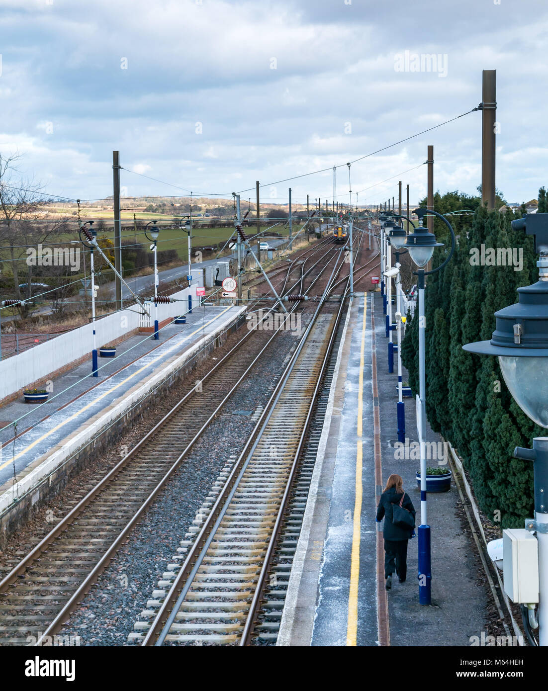 ScotRail locale treno dei pendolari lasciando Drem stazione ferroviaria, visto da sopra guardando in giù sui binari del treno e a cavi sospesi in inverno, Scotland, Regno Unito Foto Stock