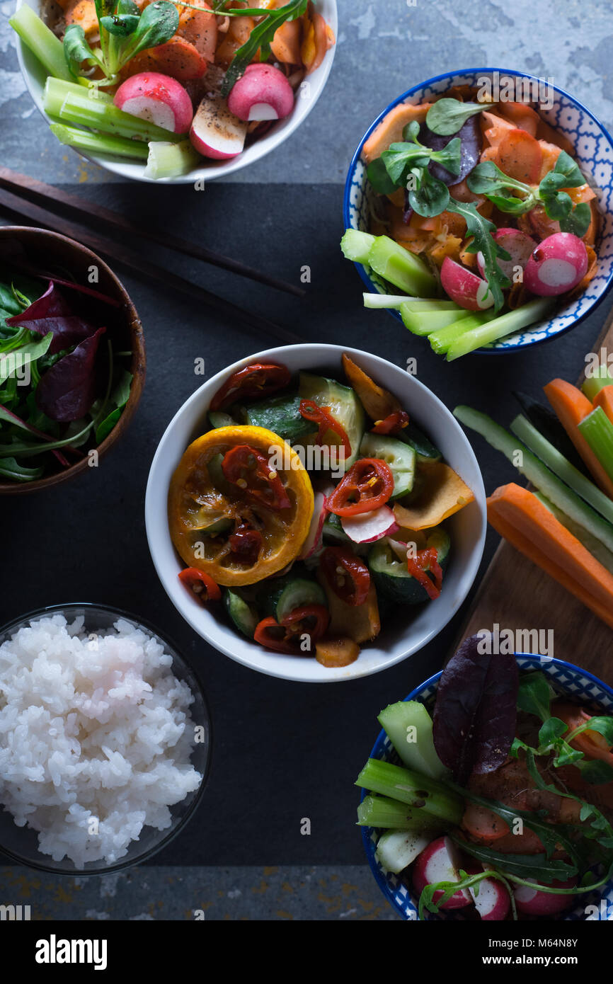 Riso, verdure sottaceto in ciotole e bacchette vista dall'alto. Cucina asiatica verticale Foto Stock