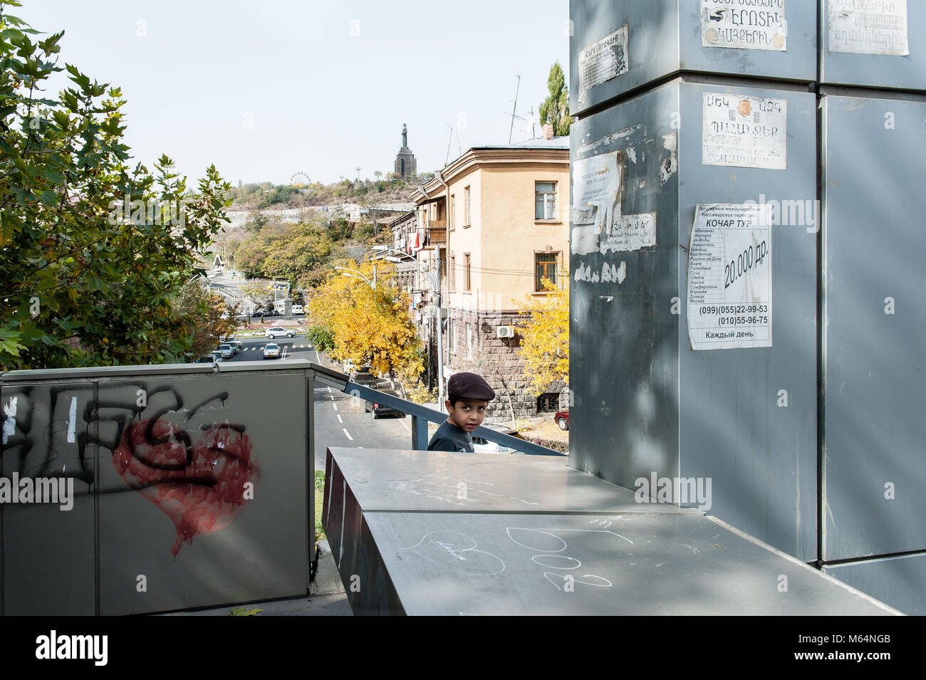 Fanciullo guardando nella telecamera mentre decending un cross over stair in Yerevan. Foto Stock