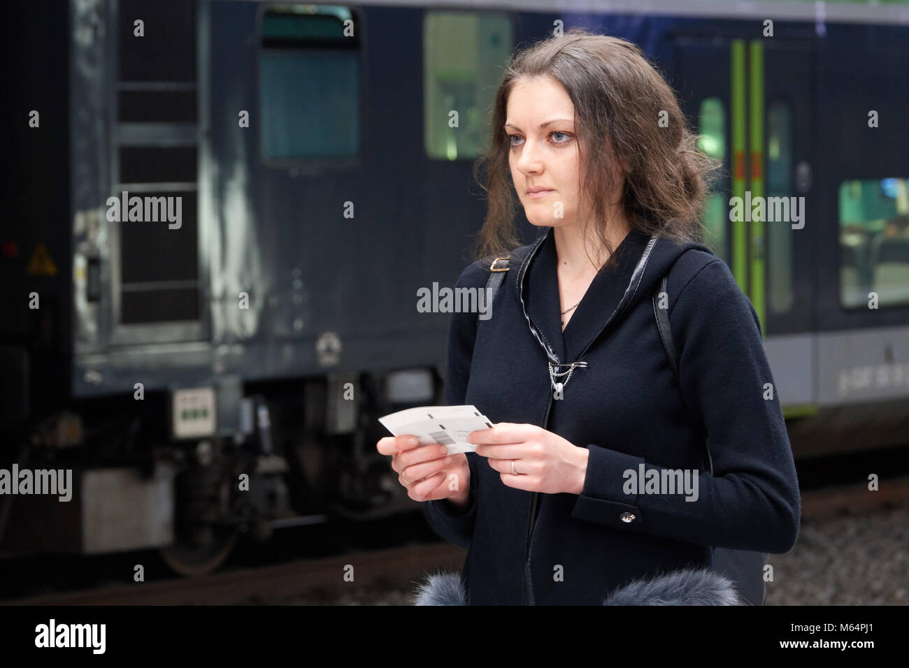 La ragazza passeggero con un biglietto in mano in attesa di un treno. Una donna che viaggia da sola. Foto Stock