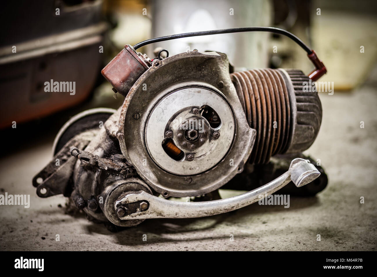 Molto sporco e olio motore dal vecchio italiano scooter sul pavimento di un garage Foto Stock