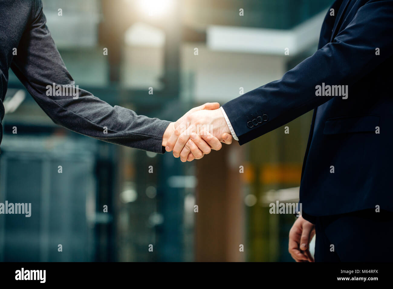 Due multirazziale handshaking gli imprenditori in un ufficio moderno per la fine della grande Foto Stock