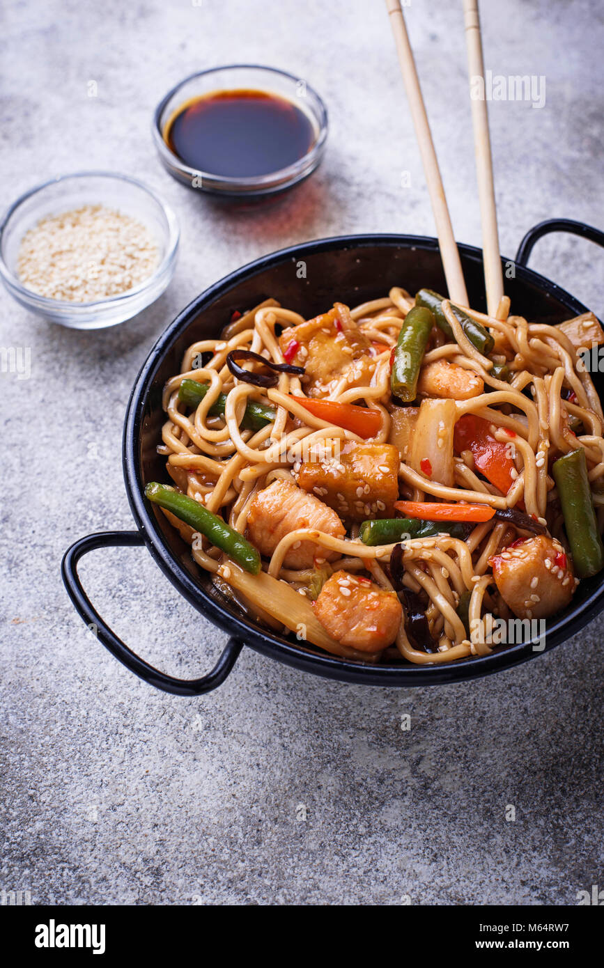 Friggere gli spaghetti con pollo, tofu e verdure. Foto Stock