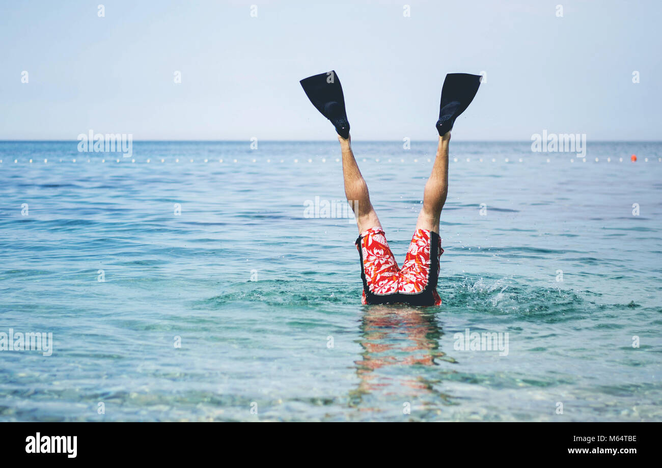 Divertimento al mare. Il maschio di gambe con le pinne per il nuoto al di sopra della superficie dell'acqua. Foto Stock