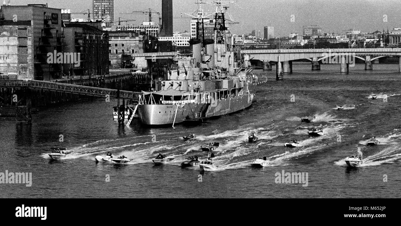 I concorrenti nel XIV London-Calais-London Power Boat Race - la gara più lunga al mondo per la National Class III power boats - spostare su Off al fianco di HMS Belfast nel pool di Londra all'inizio della prima sezione pif loro 223 miglia di viaggio. Foto Stock