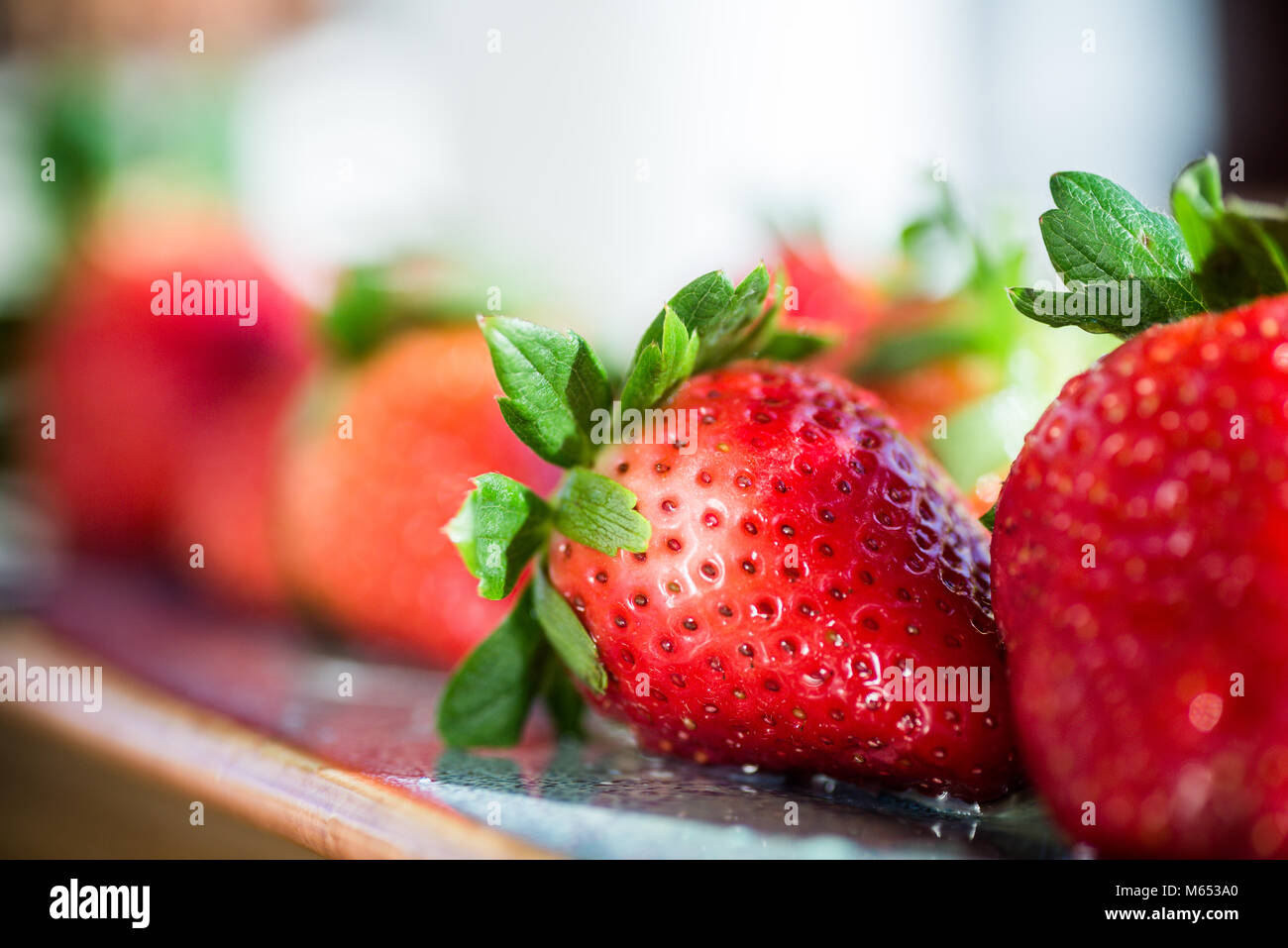 La vibrante vine ripe rosso fresco fragole. Messa a fuoco selettiva con spazio per il testo. Foto Stock