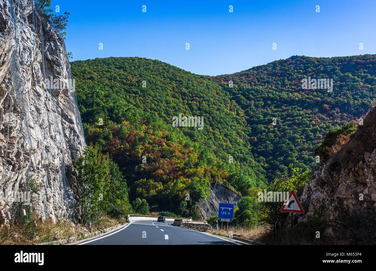 Strada di Montagna in Macedonia. Alta roccia protetti da rete in acciaio. Bel paesaggio con colorate colline coperte di bosco Foto Stock