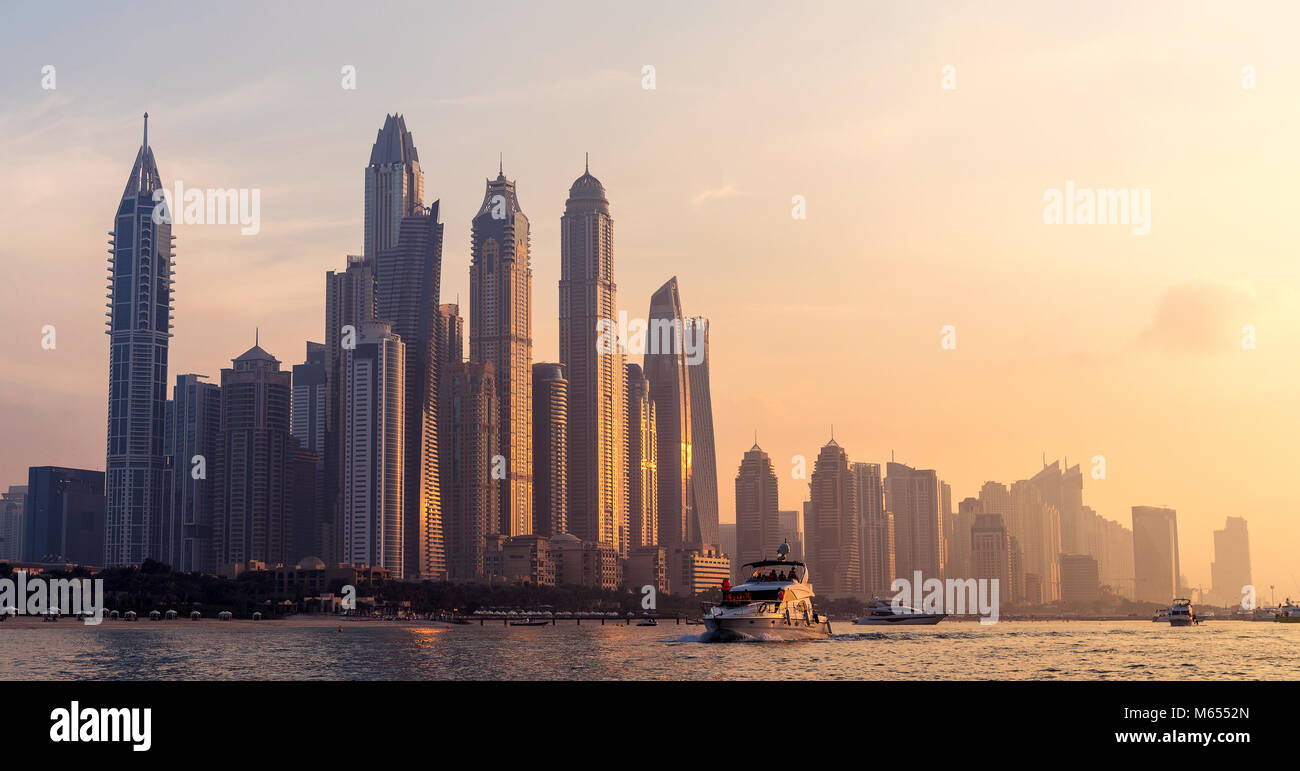 27 Dicembre 2017 - Dubai, UAE. Scenic tramonto colori che riflettono sui grattacieli. La gente in barca a vela nella parte anteriore del Marina. Foto Stock