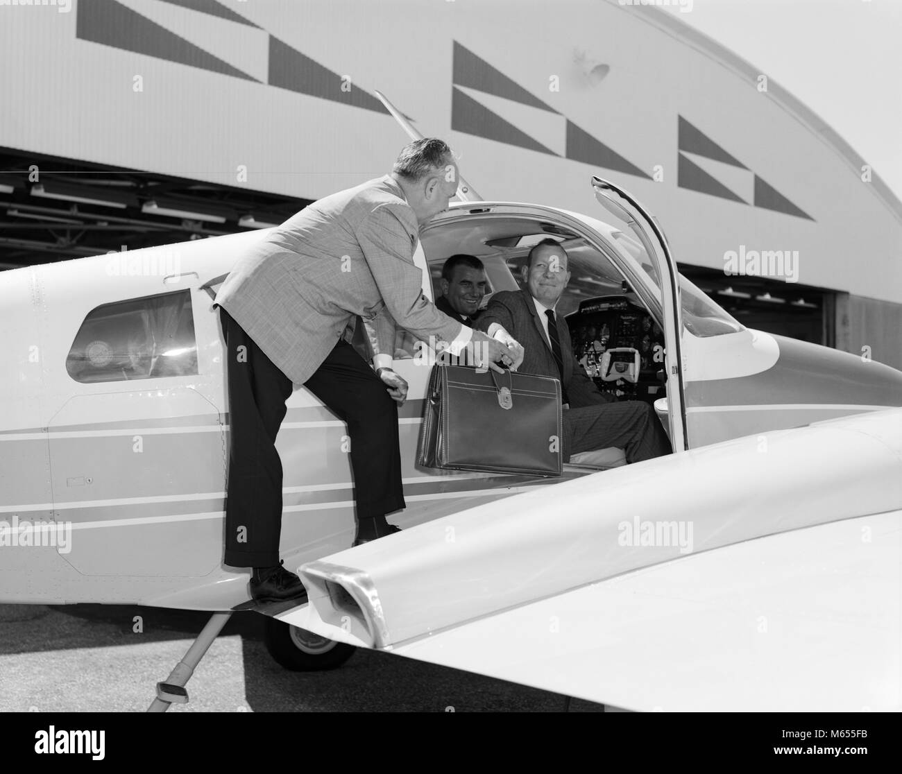 Anni sessanta imprenditori sorridente in Cessna 310G TWIN motore aereo uomo consegna valigetta in pelle per passeggero - un5808 KRU001 HARS CAUCASIAN STILE DI VITA DI LUSSO DI VELOCITÀ DI TRASPORTO PASSEGGERI spazio copia a lunghezza piena professione DI CONSEGNARE IL TRASPORTO NOSTALGIA 30-35 anni 35-40 anni lo stesso successo privato collare bianco occupazione ASSISTENZA CLIENTI CARRIERE OPPORTUNITÀ DI LEADERSHIP autorità di supporto aereo Cessna COOPERAZIONE MOBILITÀ DEI VENDITORI DI PICCOLO GRUPPO DI PERSONE DI SESSO MASCHILE MID-adulto metà uomo adulto 310G TWIN motore degli aerei B&W in bianco e nero di etnia caucasica occupazioni in vecchio stile persone Foto Stock