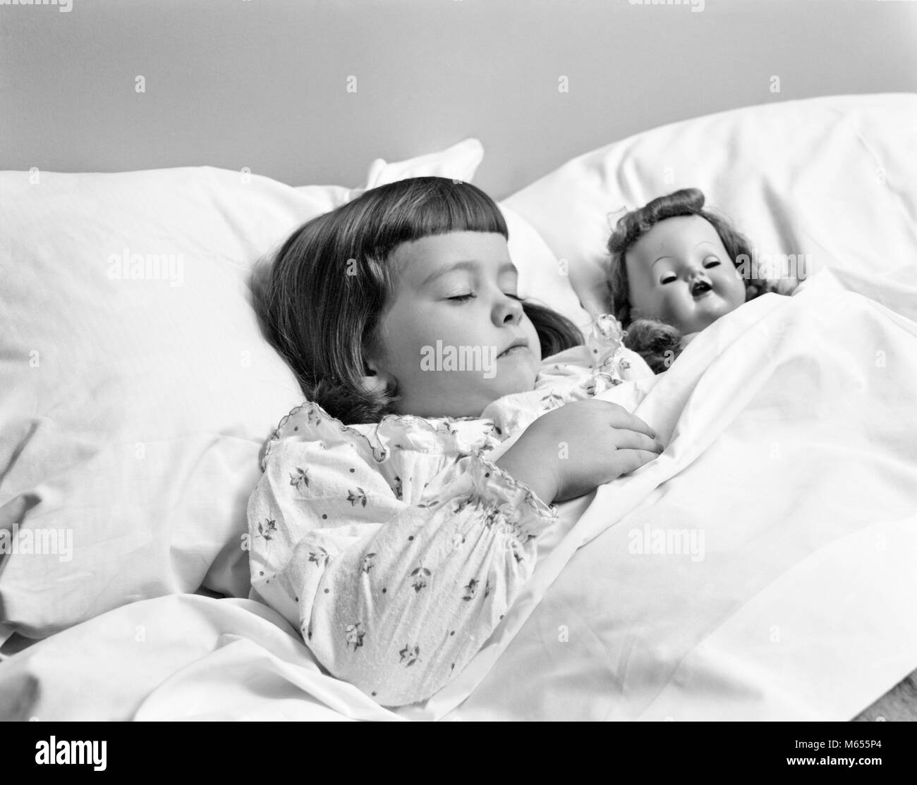 Anni Cinquanta bambina dormire con bambola giocattolo - asp x16634 CAM001 HARS B&W BANGS IN BIANCO E NERO di etnia caucasica in vecchio stile SLUMBER Foto Stock