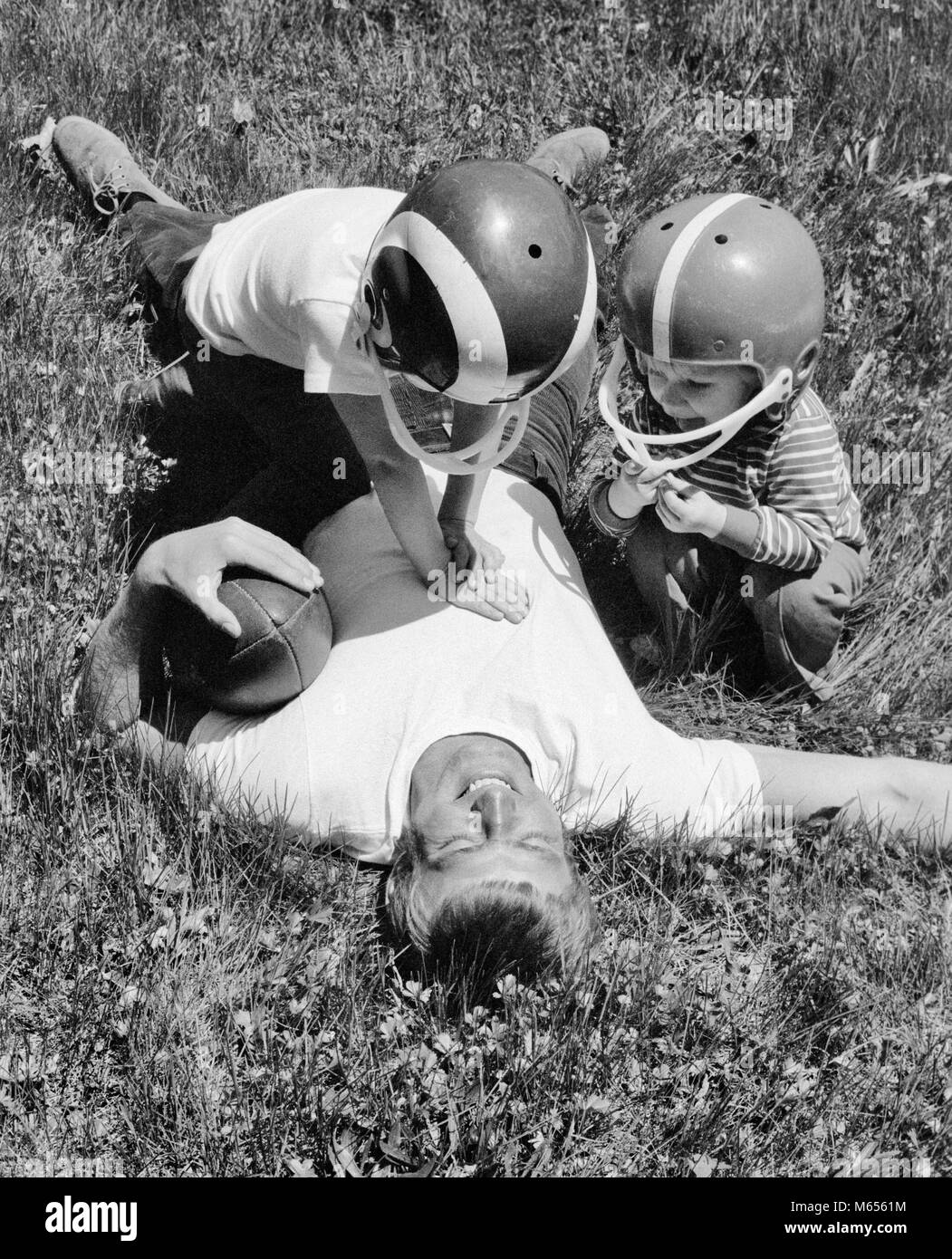 Anni Settanta uomo padre GIACENTE IN ERBA tenendo il calcio dopo essere stato affrontato dal figlio e figlia - b25063 HAR001 HARS vecchio tempo sorpresa fratello OLD FASHION SORELLA 1 capretti equilibrio di cantiere il lavoro di squadra concorrenza figli caucasica gioia LIFESTYLE FEMMINE FRATELLI SALUBRITÀ HOME vita a tutta lunghezza terreno di metà lunghezza fisica figlie cura rischio fiducia fratelli sorelle nostalgia padri convivere 25-30 anni 30-35 anni successo 5-6 anni felicità WELLNESS STRENGTH RELAX E papà emozione potente autorità di ricreazione la crescita di pari livello di cooperazione di collegamento caschi piccolo gruppo di persone Foto Stock