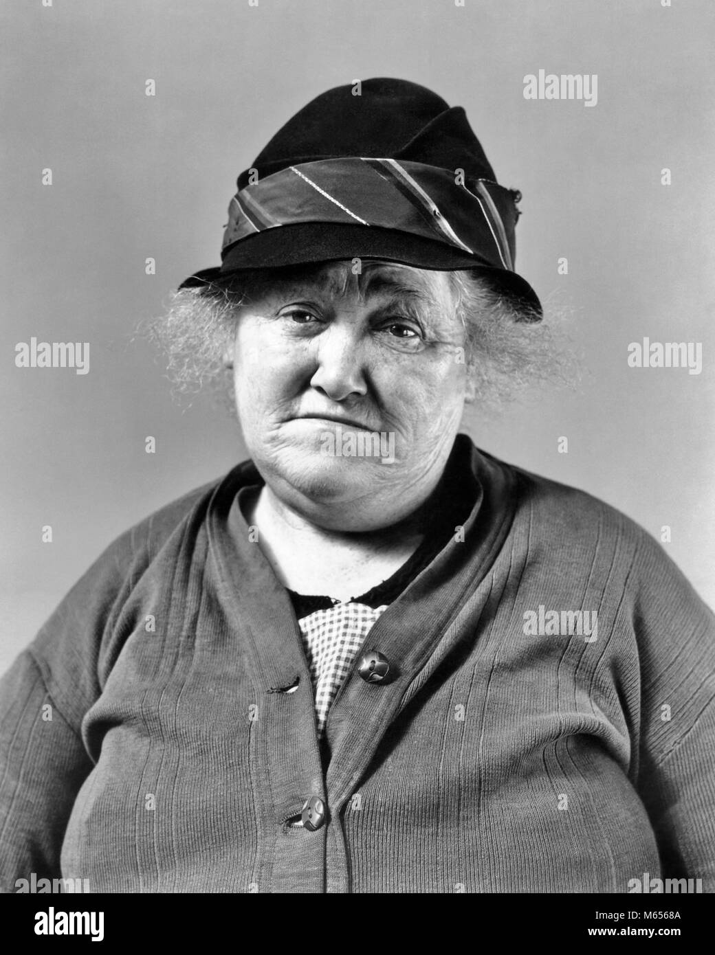 1930s depressione ERA DONNA SENIOR triste espressione facciale che indossa un maglione e HAT guardando la fotocamera - c1932 HAR001 HARS tristezza il contatto visivo senior donna donna di mezza età OLDSTERS ANTICA SUPPORTO BENESSERE Anziani misero B&W in bianco e nero di etnia caucasica ERA guardando la fotocamera in vecchio stile persone Foto Stock