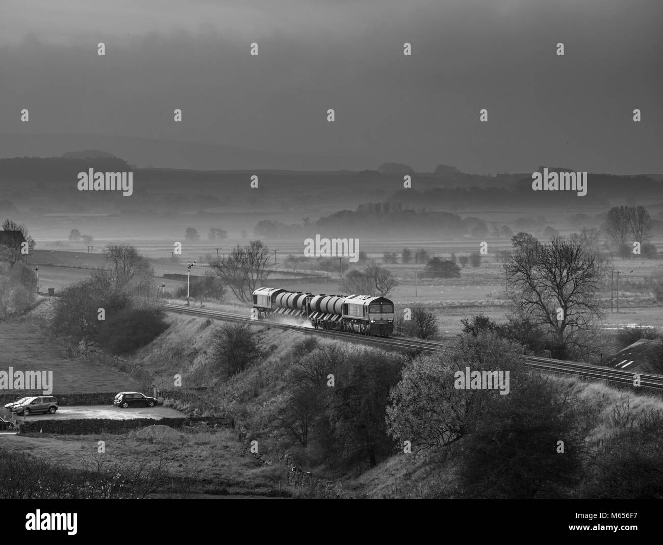2 Direct rail services class 66 locomotive pass Settle giunzione con una rampa di testa treno di trattamento di lavaggio a pressione foglia di telone da fungo della rotaia Foto Stock