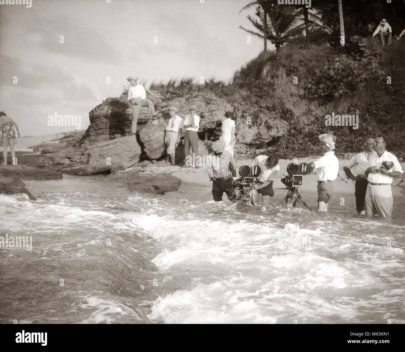 1920s registi con telecamere per film FILM DI RIPRESA NELL'ACQUA DELL'OCEANO SURF - f1079 HAR001 HARS basso angolo di attori della cooperazione cameraman GRUPPO DI PERSONE SILENT MOVIE MOTION PICTURE pubblicità ancora maschi ancora filmato SEASCAPE SEASHORE B&W in bianco e nero di etnia caucasica FILMMAKERS occupazioni in vecchio stile persone Foto Stock