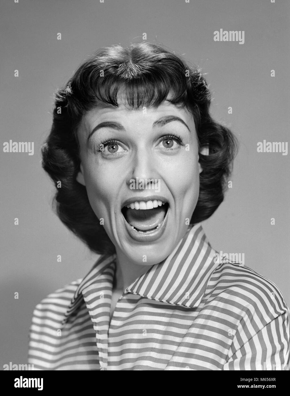 Anni Cinquanta anni sessanta donna bruna sorridente ridere BOCCA APERTA ampia felice divertente faccia guardando la telecamera a strisce che indossa camicetta - g4159 DEB001 HARS STUDIO SHOT cresciuto una sola persona in comunicazione lo spazio copia cresciuti in luoghi chiusi fiducia nostalgia ampia urlare il contatto visivo 25-30 anni 30-35 anni BRUNETTE divertente felicità testa e spalle scoperta emozione camicetta sopracciglia sorprendente comunicare YELL MID-adulto metà donna adulta Persone Adulti B&W BANGS IN BIANCO E NERO di etnia caucasica guardando la fotocamera in vecchio stile Foto Stock