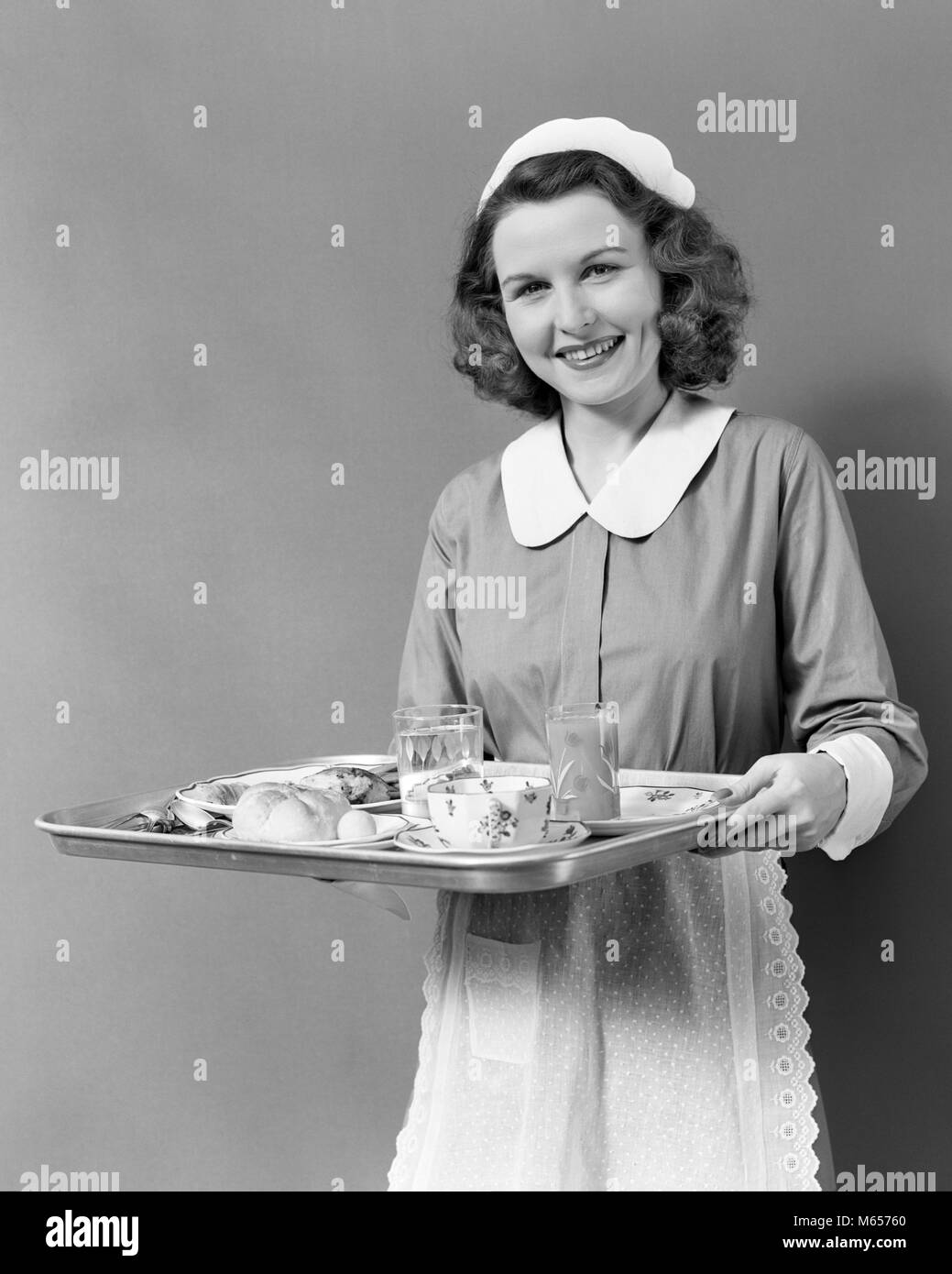 1940s cameriera cameriera vassoio di trasporto per il food service sorridente guardando telecamera - h891 HAR001 HARS contatto visivo 20-25 anni felicità allegro SERVIZIO CLIENTI 18-19 anni servo sorrisi SERVER GIOIOSA AMICHEVOLE WAITPERSON giovane donna adulta B&W in bianco e nero di etnia caucasica guardando la telecamera di occupazioni in vecchio stile persone ATTENDERE IL PERSONALE Foto Stock