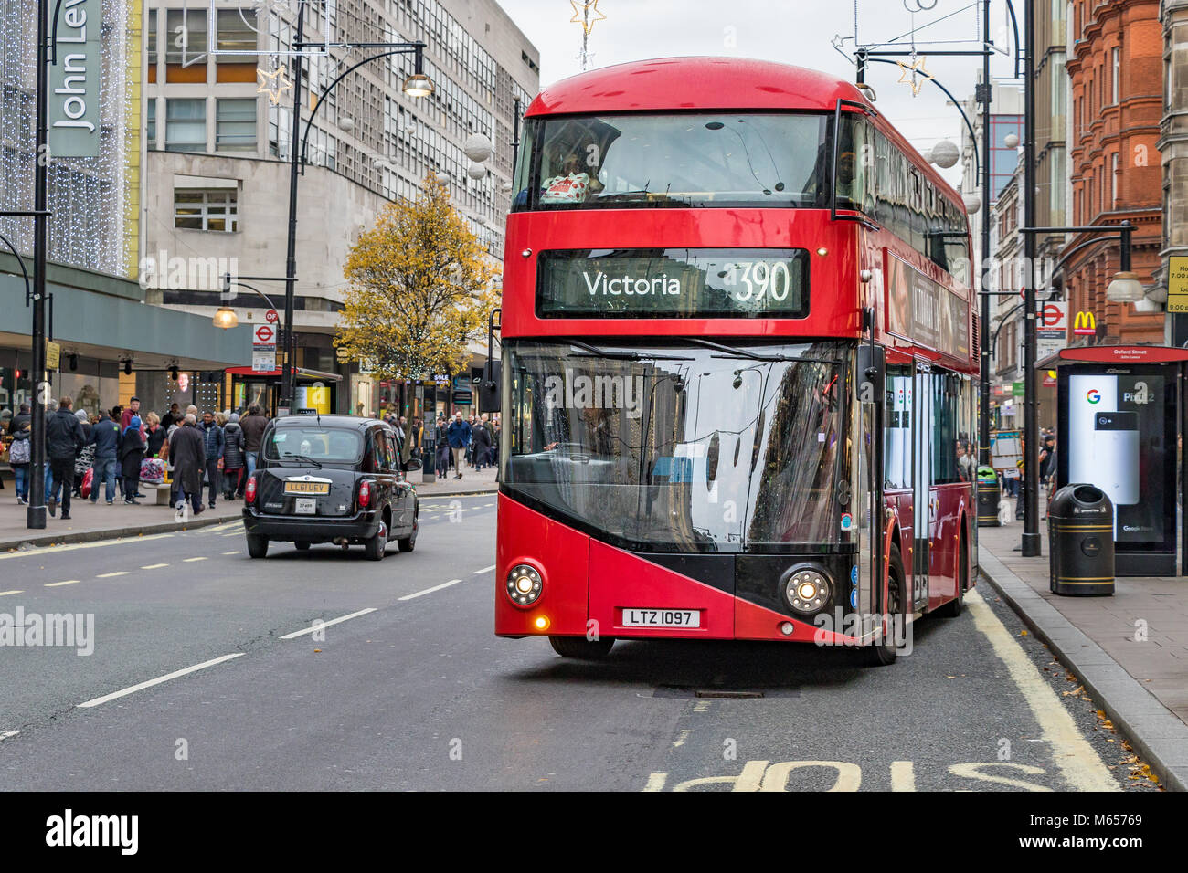 Un autobus n. 390 per Victoria, che si allontana da una fermata di autobus sulla Oxford St, Londra, Regno Unito di Londra Foto Stock