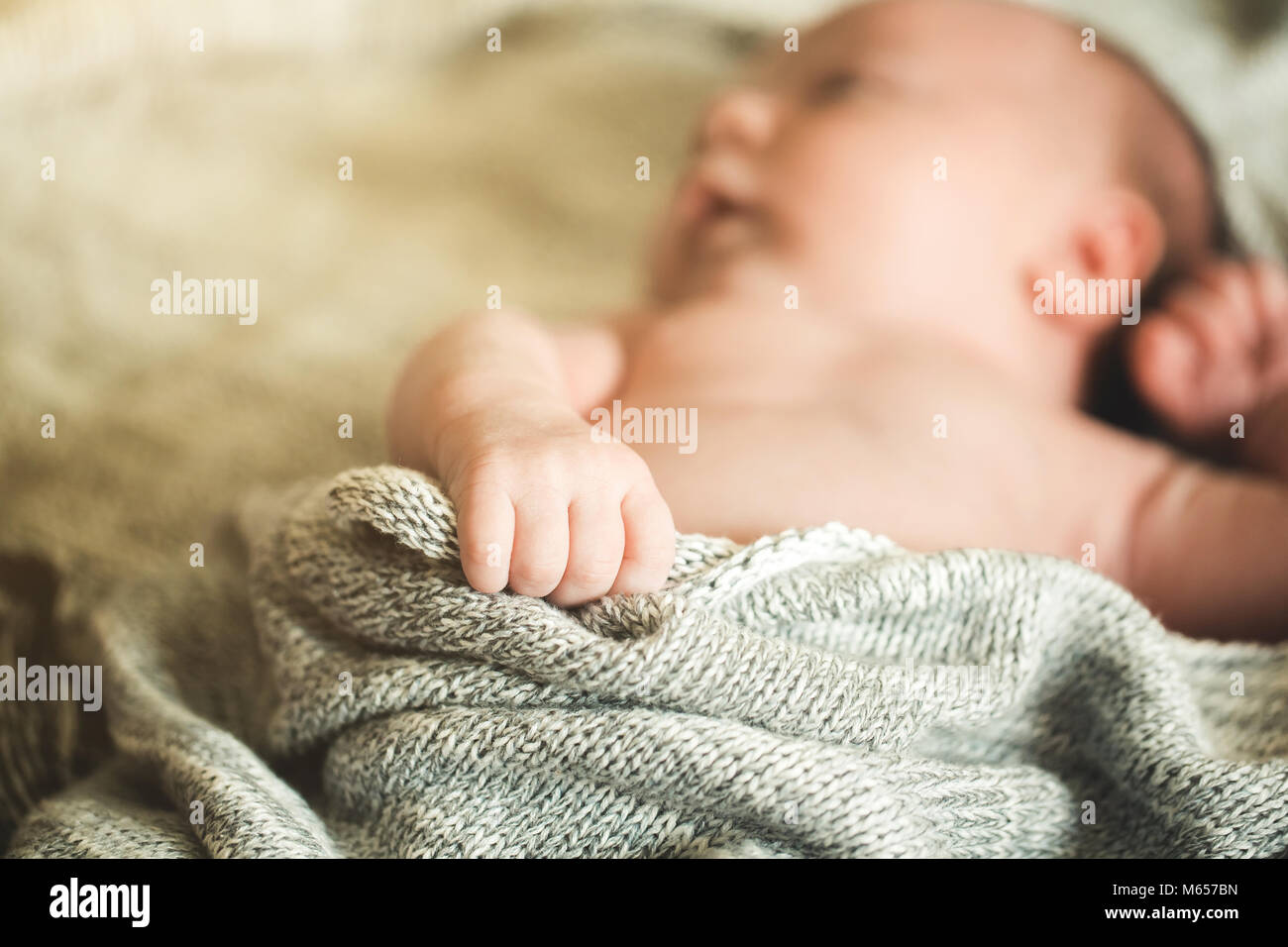 Il bambino con le mani in mano in attesa di una coperta a maglia Foto Stock